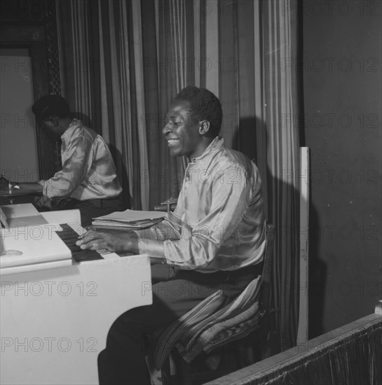 Piano player. An African musician smiles broadly as he plays a piano during a performance at the Equator Club. Nairobi, Kenya, 19 October 1957. Nairobi, Nairobi Area, Kenya, Eastern Africa, Africa.