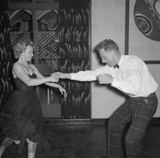 Dancing at the Equator Club. A couple dance energetically at the Equator Club. The woman, identifed as 'Wanda', wears a strapless dress that flares out as she dances. Nairobi, Kenya, 19 October 1957. Nairobi, Nairobi Area, Kenya, Eastern Africa, Africa.