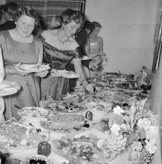 Buffet supper. Formally dressed guests at the Orme-Smith 21st birthday party queue up to help themselves to a luxurious buffet supper. Kenya, 9 November 1957. Kenya, Eastern Africa, Africa.