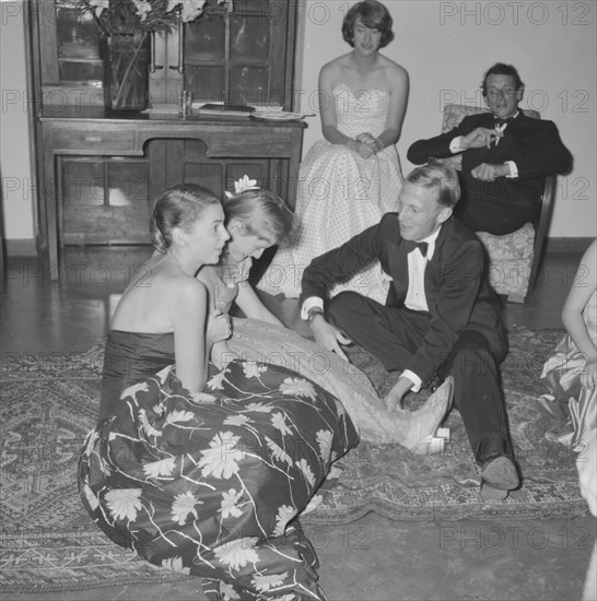 Frivolous behaviour. A young man dressed in a tuxedo teases a girl at the Orme-Smith 21st birthday party. Onlookers watch the frivolities with interest. Kenya, 9 November 1957. Kenya, Eastern Africa, Africa.