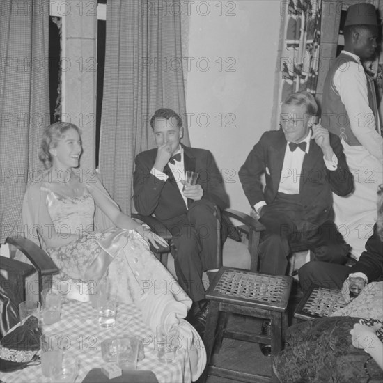 Orme-Smith 21st birthday party. A group of formally dressed young adults joke together at the Orme-Smith 21st birthday party. Kenya, 9 November 1957. Kenya, Eastern Africa, Africa.