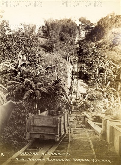 Port Antonio extension line. A roughly-built wooden railway car sits on the tracks at the bottom of a steep incline. Opening in 1896, this stretch of track was part of the Port Antonio extension line. Portland, Jamaica, circa 1895., Portland, Jamaica, Caribbean, North America .