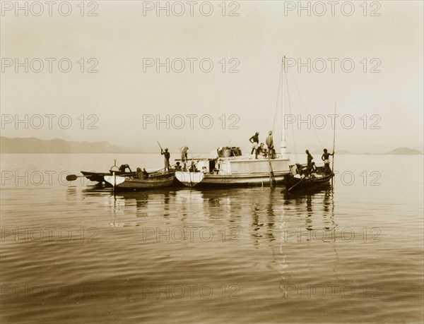 Boats on Chilka Lake. Three small boats, piloted by a team of men, float together on the calm waters of Chilka Lake. Orissa, India, circa 1940., Orissa, India, Southern Asia, Asia.