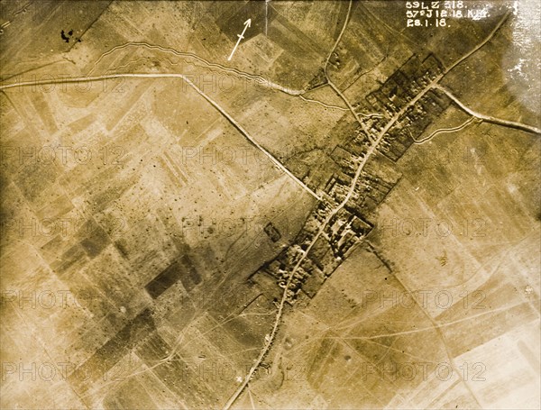 Aerial view of a bomb-damaged village. One of a series of British aerial reconnaissance photographs recording the positions of trenches on the Western Front during the First World War. Trenches zig-zag their way across fields pockmarked with bomb craters on the outskirts of a small village. Nord-Pas de Calais or Picardie, France, 28 January 1918., Nord-Pas de Calais, France, Western Europe, Europe .