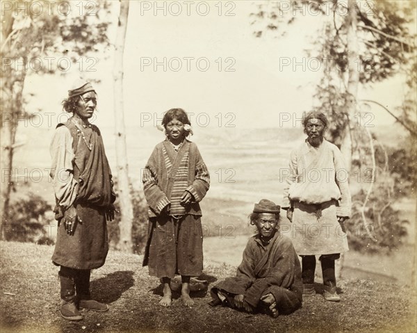 Four Bhotias. Outdoors portrait of four Bhotias in traditional dress: people from one of the several ethnic groups originating in Tibet. Probably Darjeeling, India, circa 1885. Darjeeling, West Bengal, India, Southern Asia, Asia.