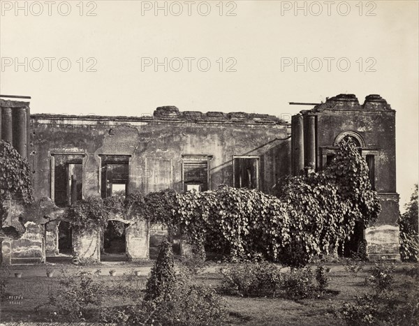 Ruins of the British Residency. The British Residency at Lucknow, ruined during the Indian Mutiny of 1857-8. This view shows the ruins of the compound's once classical banqueting hall, partially overgrown with climbing plants. Tended lawns and flowerbeds are visible in the foreground. Lucknow, North Western Provinces (Uttar Pradesh), India, circa 1880. Lucknow, Uttar Pradesh, India, Southern Asia, Asia.