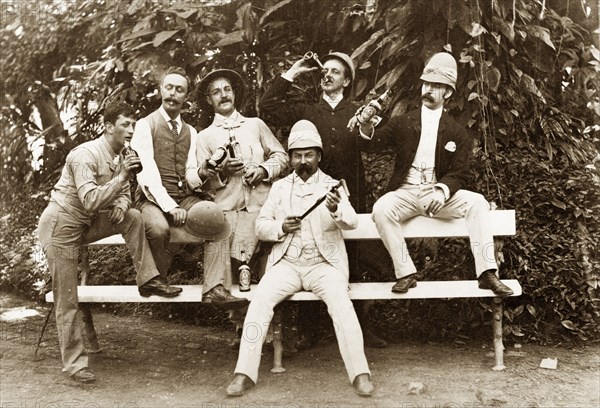 Christmas in Calcutta, 1889. Portrait of six European men celebrating Christmas in the Botanical Gardens. Smartly dressed, each man holds a bottle, the group having been deliberately posed for informal or comic affect. Calcutta (Kolkata), India, December 1889. Kolkata, West Bengal, India, Southern Asia, Asia.