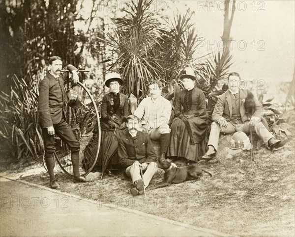 Relaxing in Eden Gardens. Group portrait of four European men and two women relaxing in Eden Gardens. The man on the left stands with a penny-farthing bicycle. Calcutta (Kolkata), India, circa 1885. Kolkata, West Bengal, India, Southern Asia, Asia.