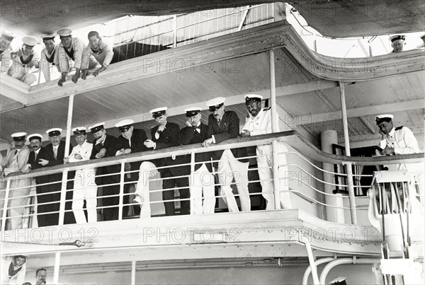 On board entertainment. King George V (r.1910-36) is entertained by a pillow fight aboard HMS Medina, accompanied by several British dignitaries dressed in naval uniform. The ship was transporting the royal couple to India for the Coronation Durbar at Delhi. Indian Ocean near Mumbai, India, 30 November 1911. India, Southern Asia, Asia.