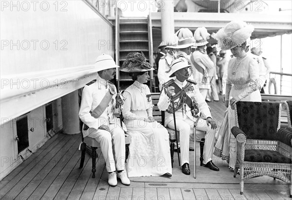Queen Mary with dignitaries. Queen Mary joins a group of seated dignitaries on the deck of HMS Medina, the royal yacht transporting King George V and Queen Mary to India for the Coronation Durbar at Delhi. Indian Ocean near Mumbai, India, circa 30 November 1911. India, Southern Asia, Asia.