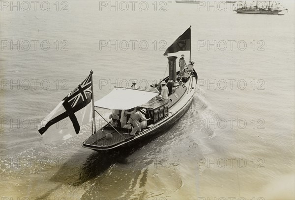 Royal barge at Bombay. A small barge decorated with flags ferries King George V (r.1910-36) and Queen Mary from HMS Medina to a landing place at Apollo Bandar. The royal couple had travelled to India for the Coronation Durbar at Delhi. Bombay (Mumbai), India, 2 December 1911. Mumbai, Maharashtra, India, Southern Asia, Asia.