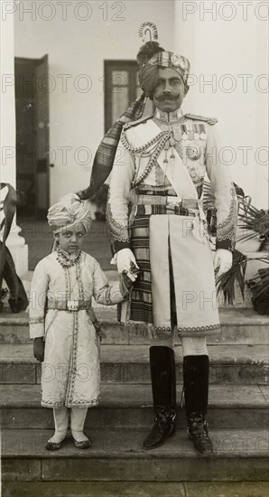 The Maharajah of Bikanir and his son. Portrait of Sir Ganga Singh, the Maharajah of Bikanir, dressed in ceremonial military uniform. He holds the hand of his young son, one of ten royal pages assigned to King George V and Queen Mary at the Coronation Durbar. Delhi, India, 12 December 1911. Delhi, Delhi, India, Southern Asia, Asia.
