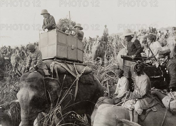 King George V on a hunt. King George V (r.1910-36) leans from the howdah on the back of his elephant during a royal hunt hosted by the Maharajah of Nepal. A related image suggests that the King has just shot a rhinoceros. Nepal, circa 18 December 1911. Nepal, Southern Asia, Asia.