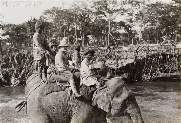 Sir Lockwood Smith-Dorien on a hunt. British Army General, Sir Horace Lockwood Smith-Dorien, rides an elephant across a river during a royal hunt in Chitwan Valley. The Maharajah of Nepal hosted the hunt for King George V shortly after the Coronation Durbar in Delhi. Narayani, Nepal, circa 18 December 1911., Narayani, Nepal, Southern Asia, Asia.