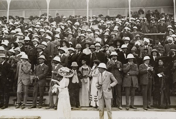 Spectators at a steeplechase. European, Indian and Eurasian spectators watch a steeplechase from stands at the Calcutta Race Course. The races were attended by King George V and Queen Mary who had travelled to India for the Coronation Durbar. Calcutta (Kolkata), India, 3 January 1912. Kolkata, West Bengal, India, Southern Asia, Asia.
