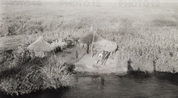 Settlement in the sudd. A tiny settlement consisting of round, thatched huts, located on a riverbank in the sudd, a vast area of swampland formed by the River Nile in southern Sudan. The photographer comments of the area: "If the Nubian desert is accounted one of the world's most barren and inhospitable regions, the sudd must be the dreariest and most featureless". Malakal, Sudan, 1946. Malakal, Upper Nile, Sudan, Eastern Africa, Africa.