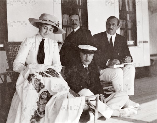 Princess Patricia on the S.S. Balmoral. Accompanied by three men from the royal entourage, Princess Patricia, daughter of the Duke of Connaught, embroiders a tablecloth on the deck of the S.S. Balmoral Castle. She was travelling with her parents who were due to open the new Union Parliament at Cape Town. Probably Atlantic Ocean, Africa, October 1910. Africa.