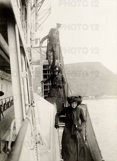 Disembarking from the S.S. Balmoral Castle. The Duke and Duchess of Connaught and their daughter, Princess Patricia, disembark from the S.S. Balmoral Castle on their arrival in St Helena. This was one of several stops made by the royal couple on their way to Cape Town to open the new Union Parliament. St Helena, 25 October 1910. St Helena, Atlantic Ocean, Africa.