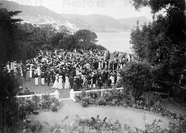 Garden party for the Duke of Connaught. Formally dressed guests socialise at a garden party held in honour of the Duke and Duchess of Connaught. This was one of several stops made by the royal couple following their official visit to Cape Town to open the new Union Parliament. Bloemfontein, Orange Free State (Free State), South Africa, 9 November 1910. Bloemfontein, Free State, South Africa, Southern Africa, Africa.
