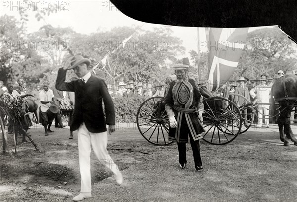 A Basuto chief visits the Duke of Connaught. One of several Basuto chiefs arrives at a reception to meet the Duke and Duchess of Connaught following their official opening of the new Union Parliament at Cape Town. He is led by a European dignitary and followed by a group of African drummers. Bloemfontein, Orange Free State (Free State), South Africa, 9 November 1910. Bloemfontein, Free State, South Africa, Southern Africa, Africa.