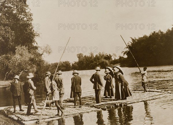 Rafting expedition. A British hunting party are ferried across the Kabani River by raft on an expedition to hunt sambhur and spotted deer. The group includes Lady Minto, Lady Eileen Elliot and the Countess of Antrim, all guests of the Maharajah of Mysore. Karnataka, India, 1909., Karnataka, India, Southern Asia, Asia.