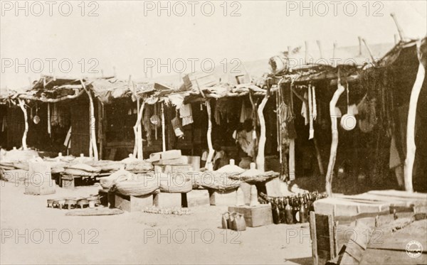 Market stalls, Khartoum. Street traders sell cooking utensils and household goods from the shade of covered market stalls. Khartoum, Sudan, circa 1910. Khartoum, Khartoum, Sudan, Eastern Africa, Africa.