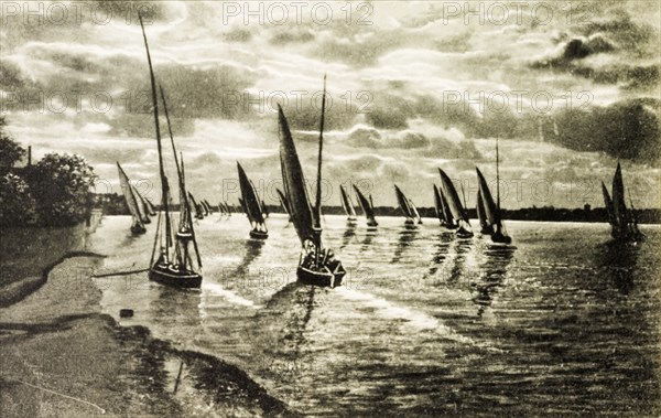 Sunset on the Nile. Sailboats at sunset, floating calmly on the waters of the River Nile. Egypt, circa 1920. Egypt, Northern Africa, Africa.