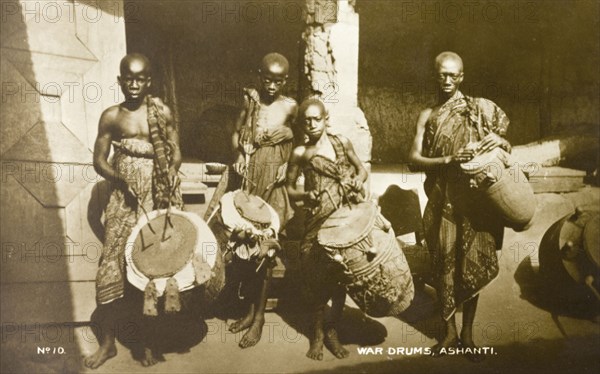 Asante drummers. Three Asante (Ashanti) boys and an adult male pose for the camera holding drums. In Asante history, drums traditionally signify a call to war for warriors and remain an inherent part of Asante culture today. Gold Coast (Ghana), circa 1910., Ashanti, Ghana, Western Africa, Africa.