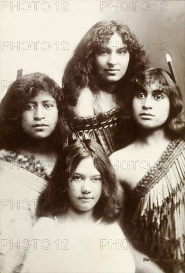 Four Maori women. Studio portrait of four young Maori women whose traditional dress has been made using the taniko weaving process. Two of the group wear decorative feathers in their hair. New Zealand, circa 1903. New Zealand, New Zealand, Oceania.