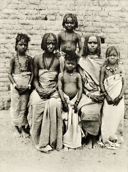 Bisharin women and children. Portrait of two Bisharin women and their four children. Their hair is braided and they wear simple robes and traditional beaded jewellery. Egypt, circa 1900. Egypt, Northern Africa, Africa.