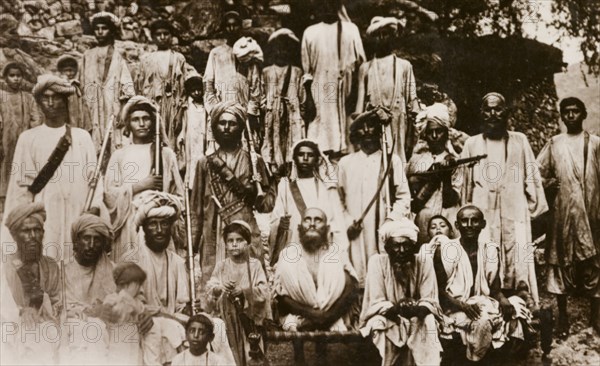 Islamic Mullah with followers. Group portrait of an Islamic Mullah with his religious followers, most of whom appear to be armed with either swords or guns. North West Frontier Province, India (Pakistan), circa 1915., North West Frontier Province, Pakistan, Southern Asia, Asia.