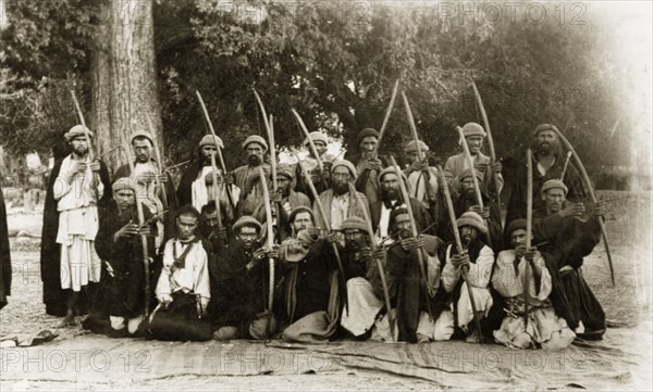 Kafir archers, Pakistan. A group of Kafir archers pose for the camera, their arrows pulled back as if ready to fire. Chitral, North West Frontier Province, India (Pakistan), circa 1915. Chitral, North West Frontier Province, Pakistan, Southern Asia, Asia.