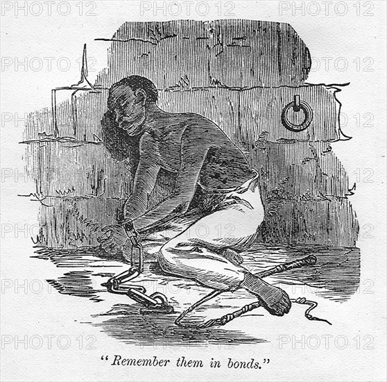 Remember them in bonds'. A slave with bound hands is chained to the floor of a cell, kneeling beside a discarded whip that is perhaps an indicator of recent punishment. An original caption quotes a line from the Bible: 'Remember them in bonds'. Probably Caribbean, circa 1820., Caribbean, North America .