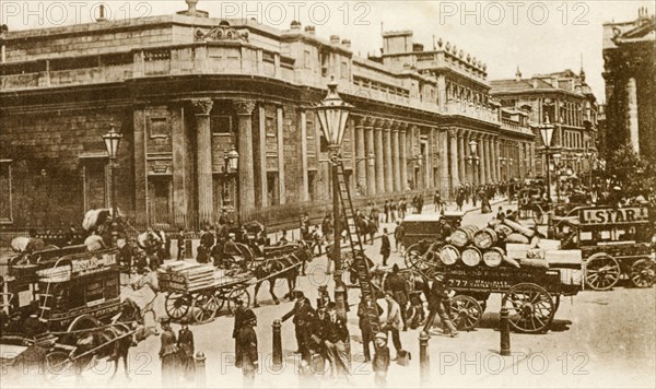 Outside the Bank of England. Horse-drawn carriages and pedestrians bustle about on a street running past the Bank of England. A lamp cleaner can be seen in the foreground, his ladder propped up against a lamppost. London, England, circa 1890. London, London, City of, England (United Kingdom), Western Europe, Europe .