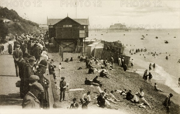 Folkestone beach. A crowd of people gaze from a promenade above a beach scattered with seaside bathers. Folkestone, England, circa 1900. Folkestone, Kent, England (United Kingdom), Western Europe, Europe .