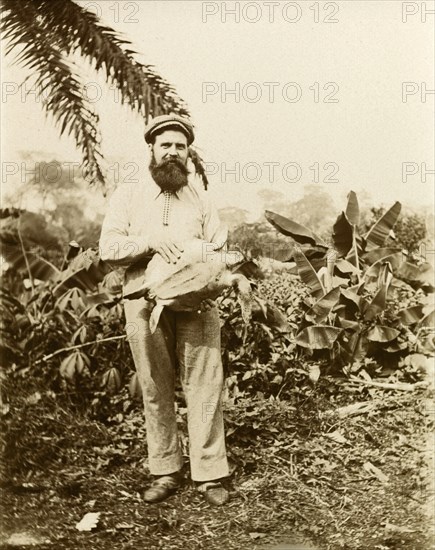 A British missionary on Bioko. A British Primitive Methodist missionary based on the island of Bioko, poses for the camera holding a sea turtle. Bioko, Equatorial Guinea, circa 1930., Bioko Norte, Equatorial Guinea, Central Africa, Africa.