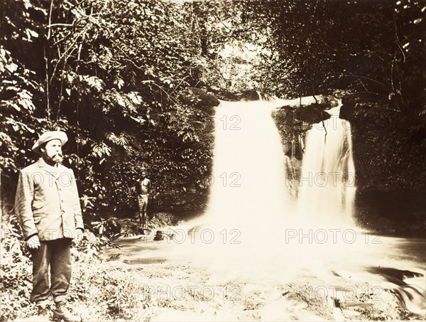 A British missionary on Bioko. A British Primitive Methodist missionary stands pensively beside a jungle waterfall. Bioko, Equatorial Guinea, circa 1930., Bioko Norte, Equatorial Guinea, Central Africa, Africa.