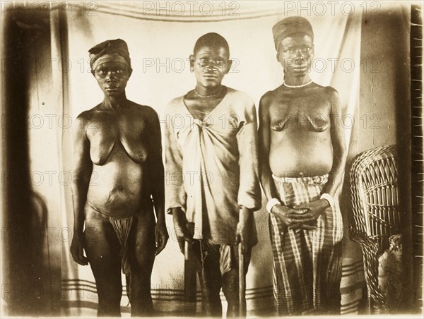 Inhabitants of Bioko. Portrait of a two women and a man from Bioko, posed standing against a makeshift backdrop. Bioko, Equatorial Guinea, circa 1930., Bioko Norte, Equatorial Guinea, Central Africa, Africa.
