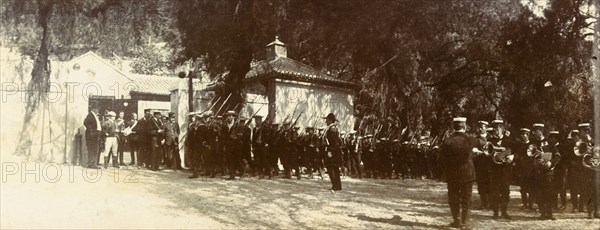 Military march in Gibraltar. A military regiment marches past a gateway, their bayonets resting on their shoulders. This is one of several photographs taken during a royal visit to Gibraltar by King Edward VII (1841-1910) and Kaiser Wilhelm II (1859-1941), and may feature the monarchs themselves. Gibraltar, 1904., Gibraltar, Gibraltar, Mediterranean, Europe .