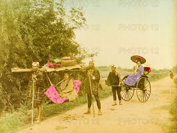 Travelling in style. Two young Japanese women, finely dressed in traditional kimonos, travel in style along a rural road. One is carried in a 'kago' supported by two men, whilst the other is pulled along in an open rickshaw. Japan, circa 1910. Japan, Eastern Asia, Asia.