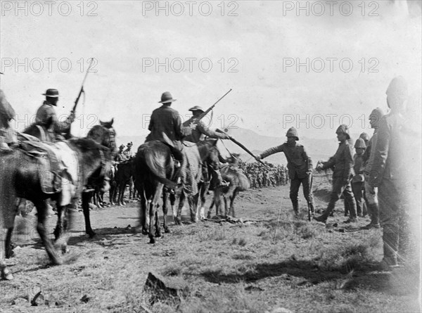 Boer fighters surrender at Slaapkrans. Boer fighters relinquish their rifles to British forces at 'Surrender Hill', following a battle at Slaapkrans during the Second Boer War (1899-1902). Near Slaapkrans, Orange River Colony (Free State), South Africa, 30 July 1900. Slaapkrans, Free State, South Africa, Southern Africa, Africa.