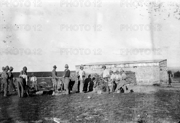 A fatigue party digging, South Africa. A group of officers in the East Surrey Regiment, dig the earth at a British military camp during the Second Boer War (1899-1902). They are part of a 'fatigue party', a group of soldiers assigned to a non-military task. South Africa, circa 1900. South Africa, Southern Africa, Africa.