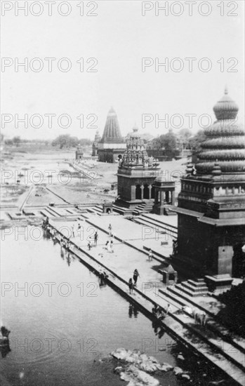 Pilgrims bathing at Wai. Religious pilgrims bathe in the shadows of ornate temples on the River Krishna. Wai, Maharashtra, India, circa 4 June 1926. Wai, Maharashtra, India, Southern Asia, Asia.