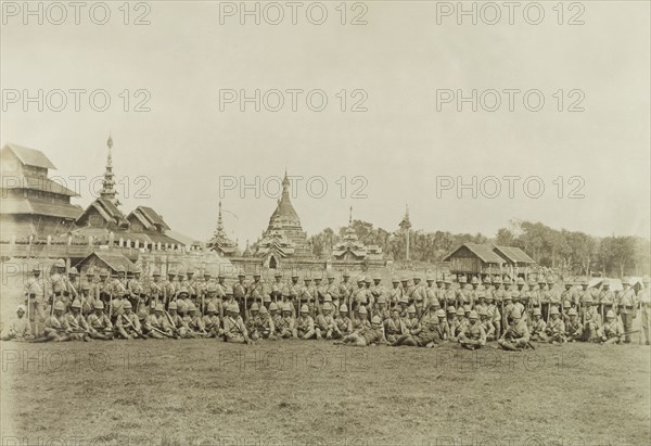 The Second Devonshire Regiment. The Second Devonshire Regiment of the British Army, led by Captain Davies, poses for a group portrait in front of Wuntho Palace and the town's 'Pon-gyi kyaunga' (Buddhist monastery). The group are pictured shortly after British forces captured Wuntho following a conflict with Burmese rebels. Wuntho, Burma (Myanmar), 1891. Wuntho, Sagaing, Burma (Myanmar), South East Asia, Asia.