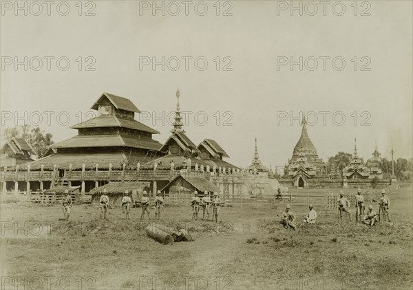 Wuntho Palace and the 'Pon-gyi kyaung'. British Army soldiers pose in front of Wuntho Palace (left) and the town's 'Pon-gyi kyaung' (Buddhist monastery). The group are pictured shortly after British forces captured Wuntho following a conflict with Burmese rebels. Wuntho, Burma (Myanmar), 1891. Wuntho, Sagaing, Burma (Myanmar), South East Asia, Asia.