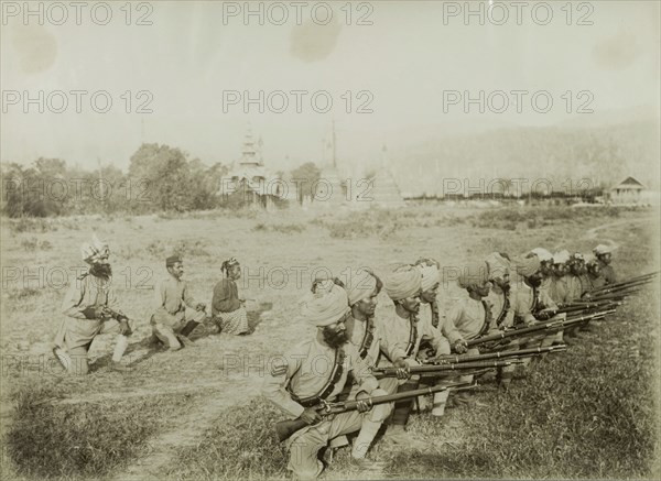 Practising a shooting stance. Turbaned Indian Military and Civil Police officers practice their shooting stances on the outskirts of Wuntho, crouched down on one knee, their rifles at the ready. These forces supported the British Army in a campaign to suppress Burmese rebels in Wuntho State (Sagaing Division). Wuntho, Burma (Myanmar), 1891. Wuntho, Sagaing, Burma (Myanmar), South East Asia, Asia.