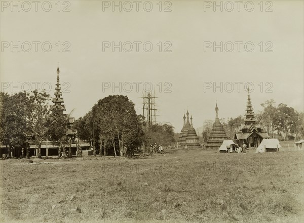View of Wuntho, Burma (Myanmar). View of Wuntho showing the town's palace (left) and several carved stone 'zeidis' or pagodas. British Army soldiers stand near their tents in the foreground, pictured shortly after British forces captured Wuntho following a conflict with Burmese rebels. Wuntho, Burma (Myanmar), 1891. Wuntho, Sagaing, Burma (Myanmar), South East Asia, Asia.
