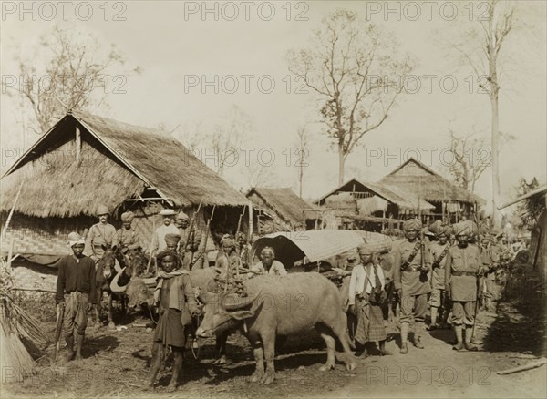 Village at the Morgandine Pass. Armed British and Indian soldiers pose beside a bullock-drawn cart in a village at the Morgandine Pass. Possibly a mix of British Army and Military Police officers, the men were involved in a campaign to suppress Burmese rebels in Wuntho State (today known as the Sagaing Division). Sagaing, Burma (Myanmar), 1891., Sagaing, Burma (Myanmar), South East Asia, Asia.
