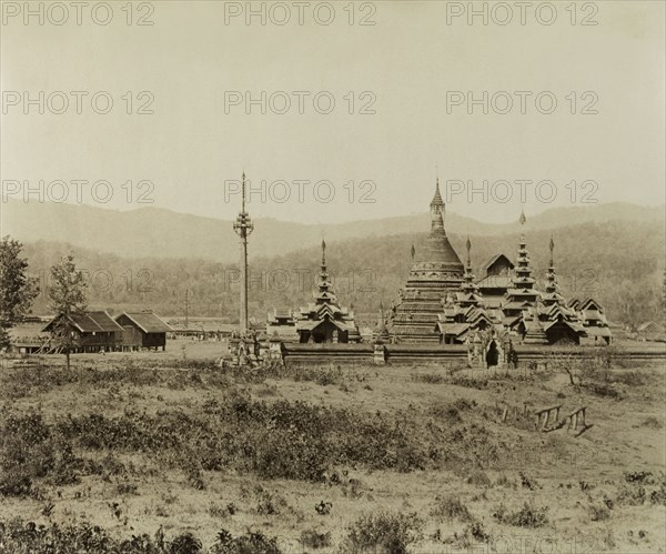 The 'Pon-gyi kyaunga' at Wuntho. View of the 'Pon-gyi kyaunga' (Buddhist monastery) at Wuntho. A telegraph pole stands to the left of the complex beside two wooden buildings identified as the 'post and telegraph offices'. This scene was captured shortly after British forces took control of Wuntho following a conflict with Burmese rebels. Wuntho, Burma (Myanmar), 1891. Wuntho, Sagaing, Burma (Myanmar), South East Asia, Asia.