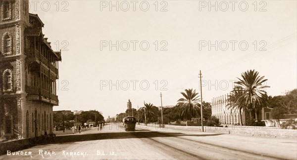 Bunder Road in Karachi. A view down Bunder Road (Mohammad Ali Jinnah Road) in Karachi, a wide street lined with trees and dotted with multi-storey, English-style buildings. Karachi, India (Pakistan), circa 1910. Karachi, Sindh, Pakistan, Southern Asia, Asia.